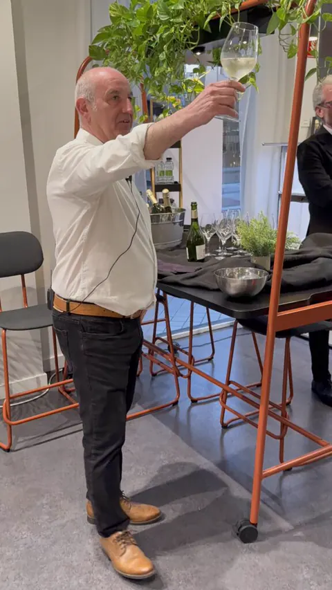Un ponente con una copa en la mano durante la cata en el showroom de Lara